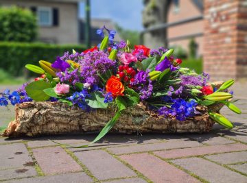 Rouwarrangement op boomschors voor een natuurbegraafplaats